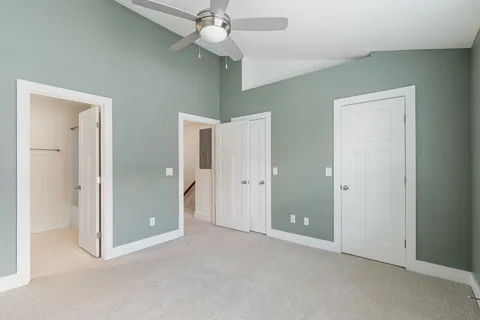 a view of an empty room and chandelier fan