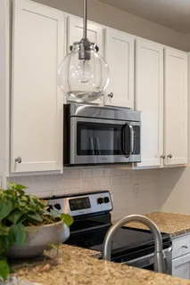 a kitchen with stainless steel appliances granite countertop a stove a microwave and cabinets
