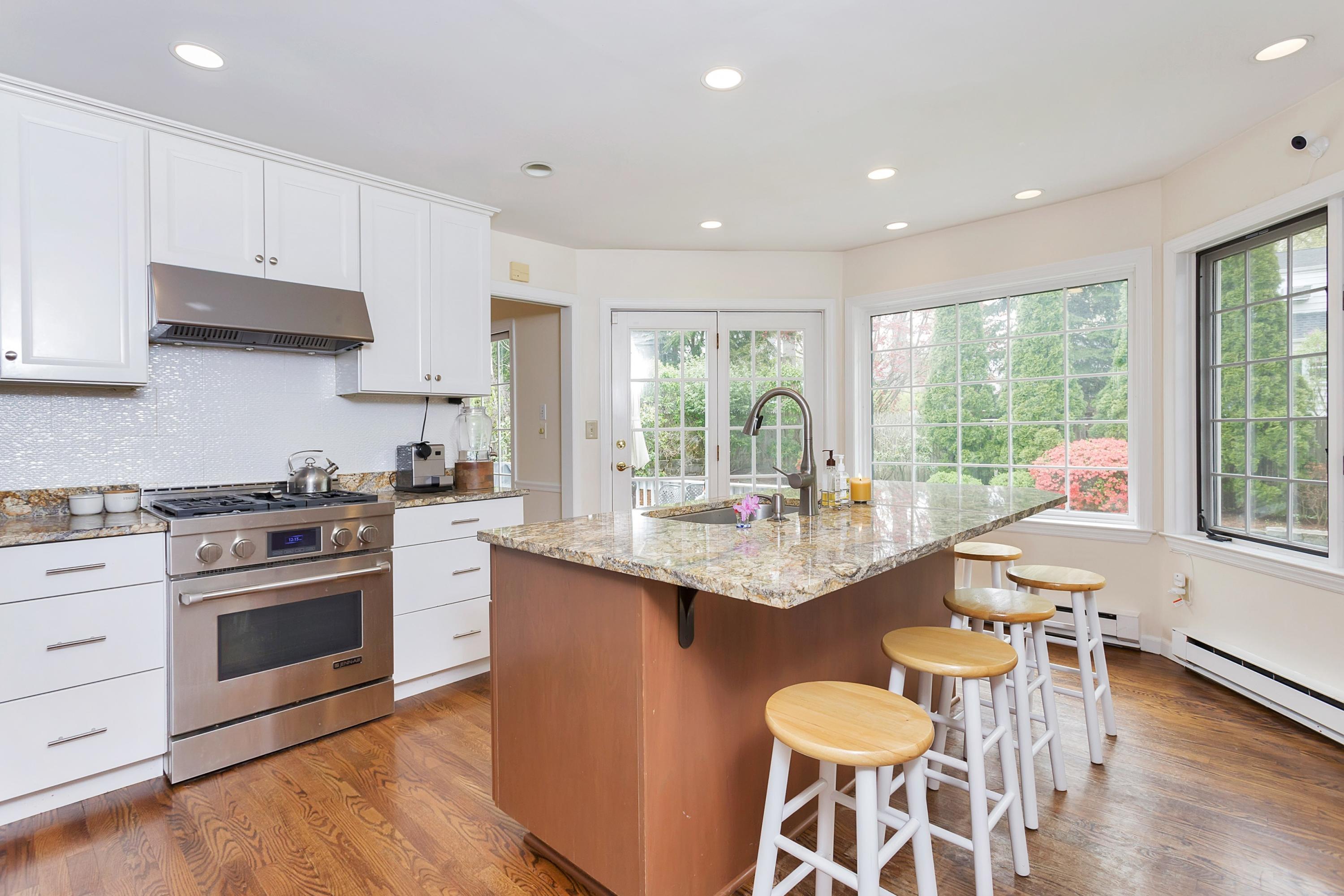 25 Bramble Lane Riverside, CT 06878 - Photo 3 of 10 a kitchen with granite countertop a stove a sink a dining table and chairs