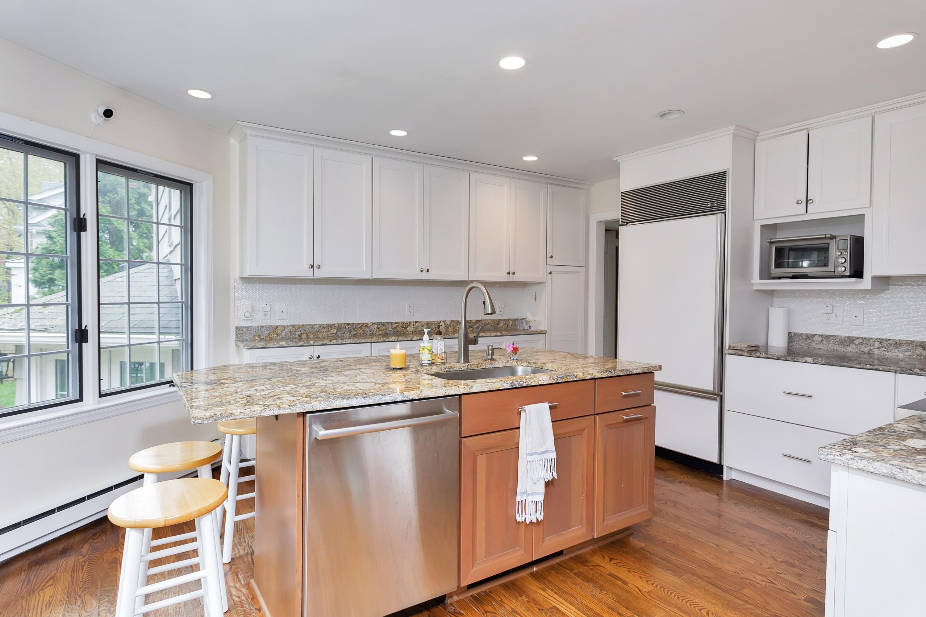 25 Bramble Lane Riverside, CT 06878 - Photo 4 of 10 a kitchen with stainless steel appliances granite countertop a refrigerator a sink dishwasher a stove and white countertops with wooden floor