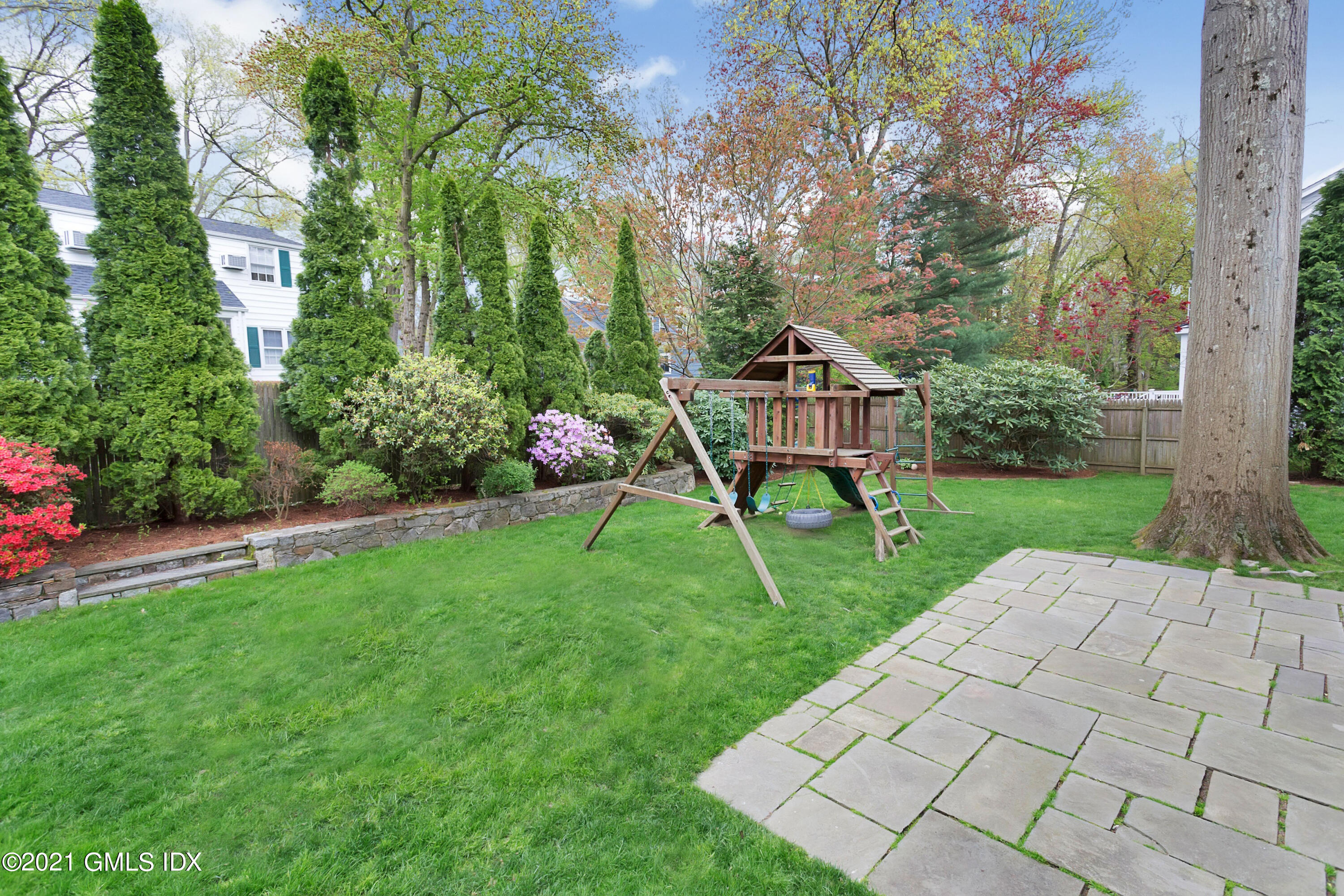 25 Bramble Lane Riverside, CT 06878 - Photo 8 of 10 a view of a backyard with table and chairs and potted plants and large trees