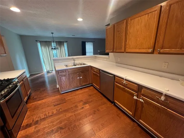 a kitchen with kitchen island granite countertop a sink cabinets and wooden floor