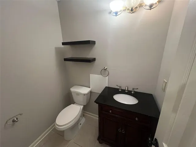 a bathroom with a granite countertop toilet and a sink
