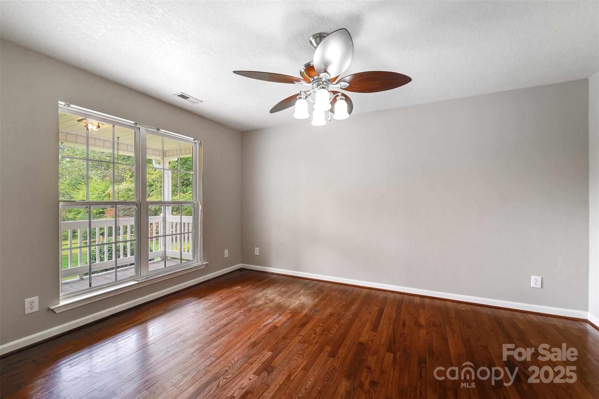 1061 Calvary Church Road Sylva, NC 28779 - Photo 12 of 46 an empty room with wooden floor fan and windows