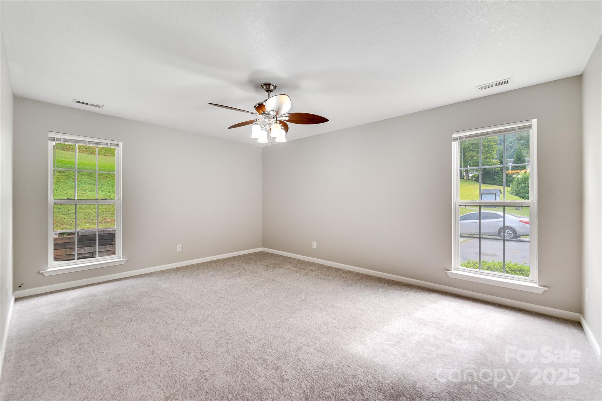 1061 Calvary Church Road Sylva, NC 28779 - Photo 18 of 46 an empty room with windows and chandelier fan