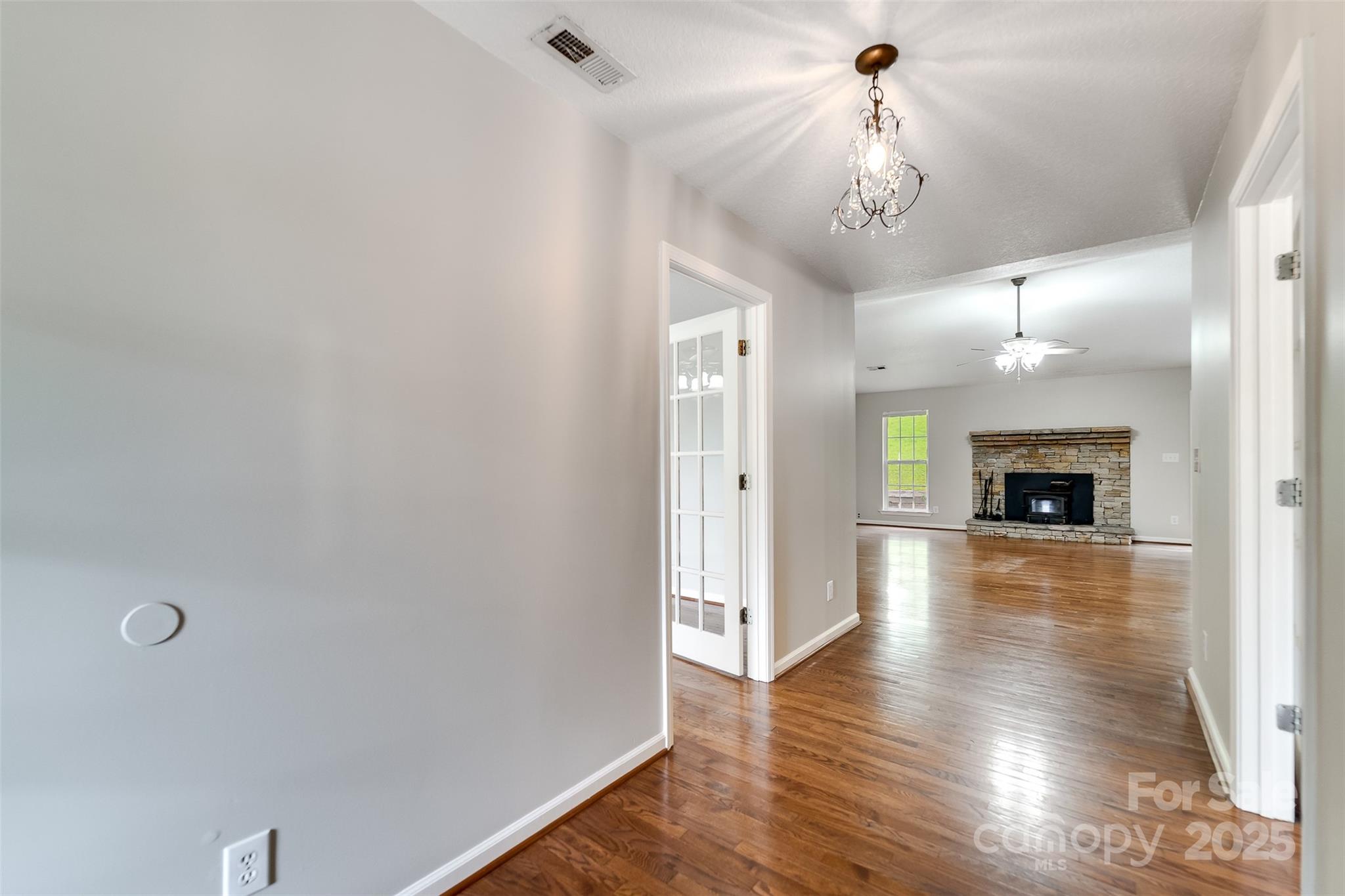 1061 Calvary Church Road Sylva, NC 28779 - Photo 8 of 46 a view of a livingroom with a fireplace wooden floor and a chandelier
