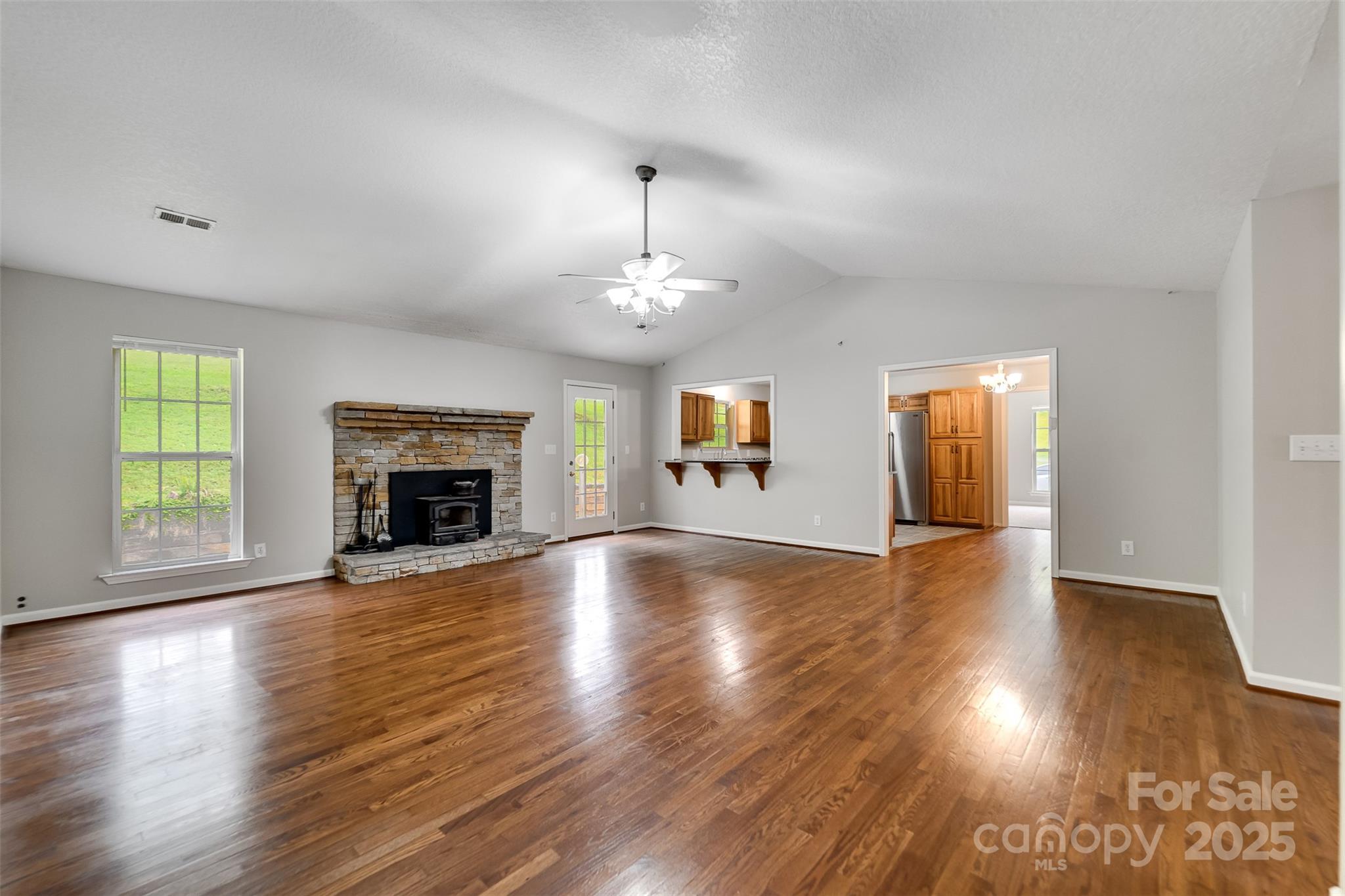 1061 Calvary Church Road Sylva, NC 28779 - Photo 10 of 46 an empty room with wooden floor fireplace and windows