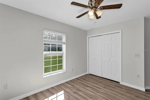 a view of an empty room with window and wooden floor