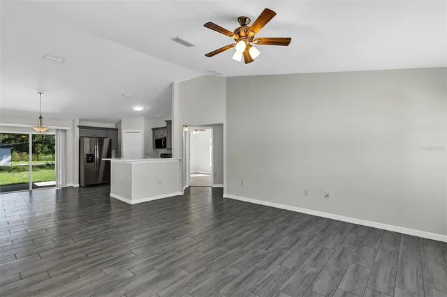 a view of a kitchen with wooden floor and a ceiling fan