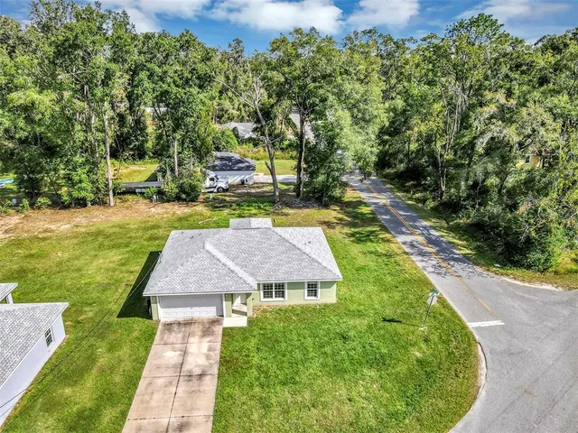 a aerial view of a house with a yard table and chairs