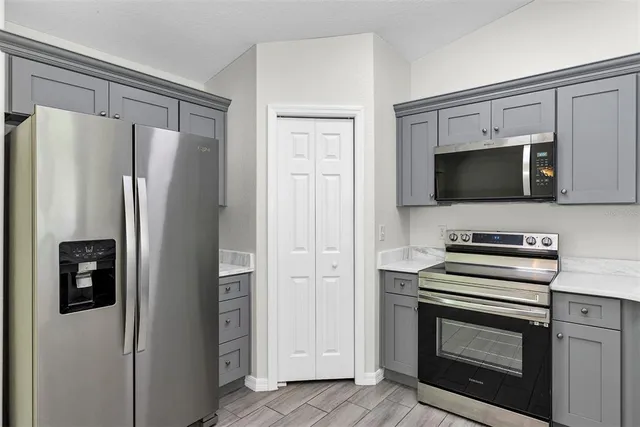 a kitchen with stainless steel appliances a refrigerator stove and microwave