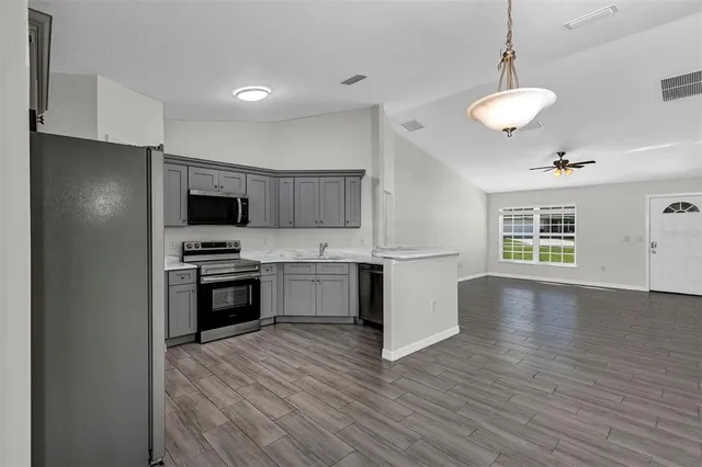 a kitchen with a refrigerator and a stove top oven