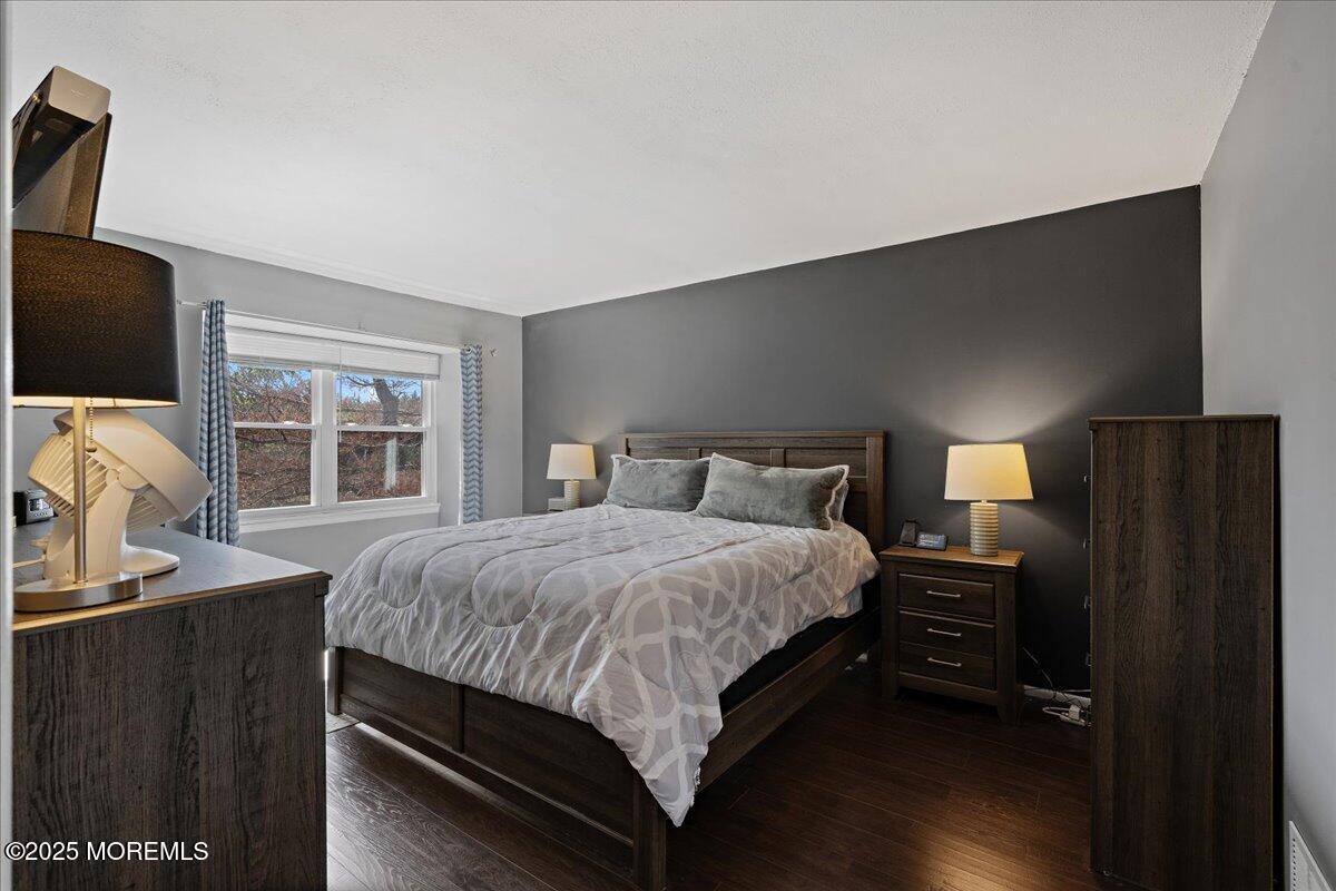 550 Labanna Court Brick, NJ 08724 - Photo 13 of 38 a bedroom with a bed and a flat tv screen on a dresser