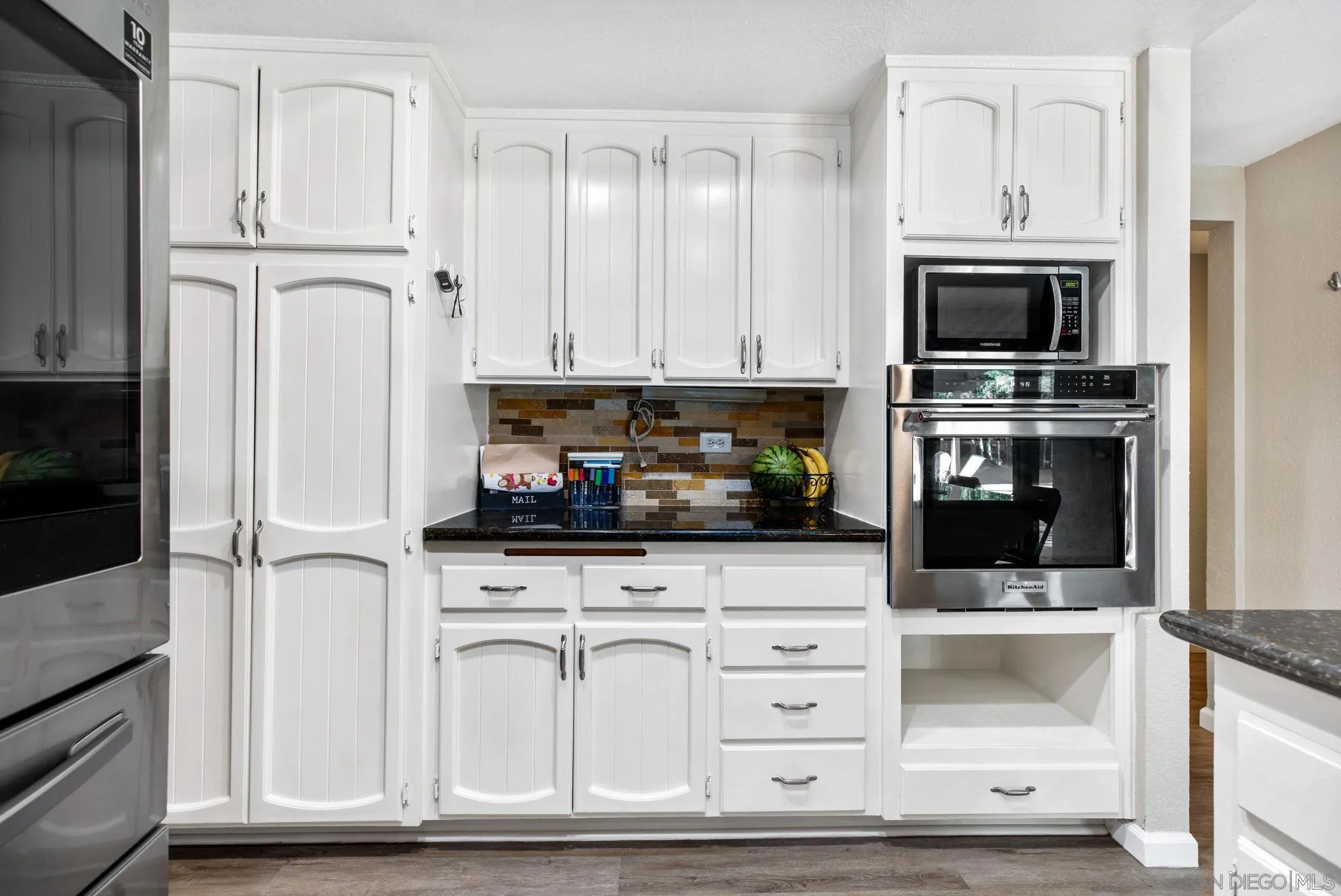 16614 Wikiup Road Ramona, CA 92065 - Photo 13 of 37 a kitchen with white cabinets and appliances