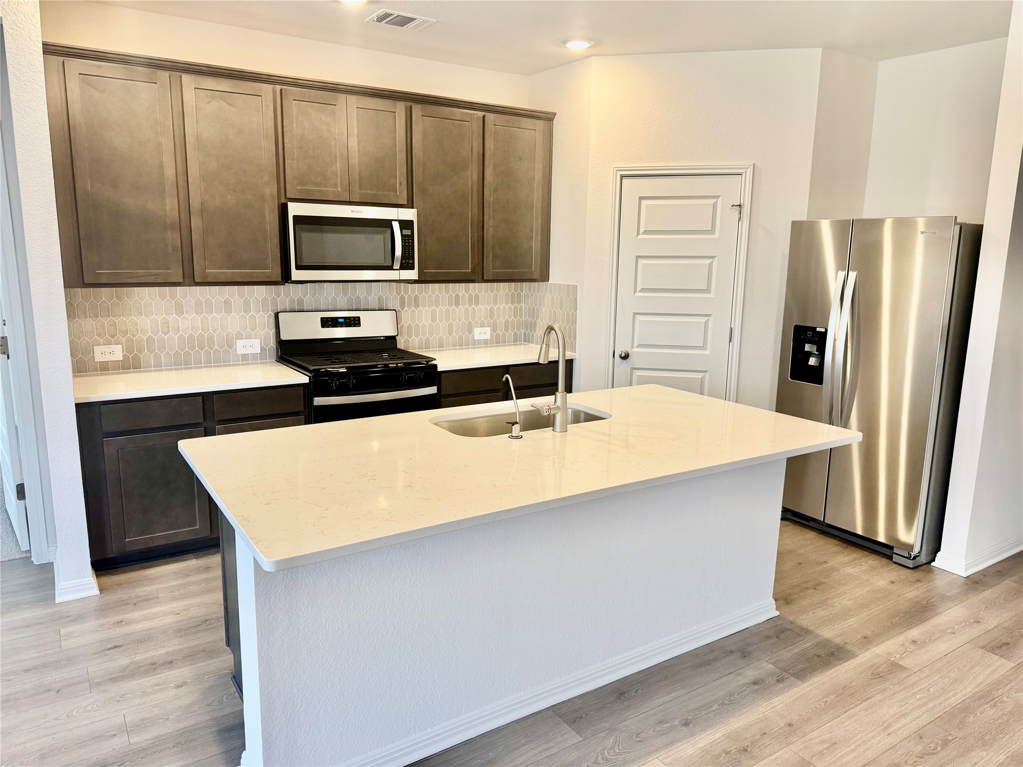 478 El Capitan Loop Dripping Springs, TX 78620 - Photo 2 of 14 a kitchen with stainless steel appliances a microwave a sink and refrigerator