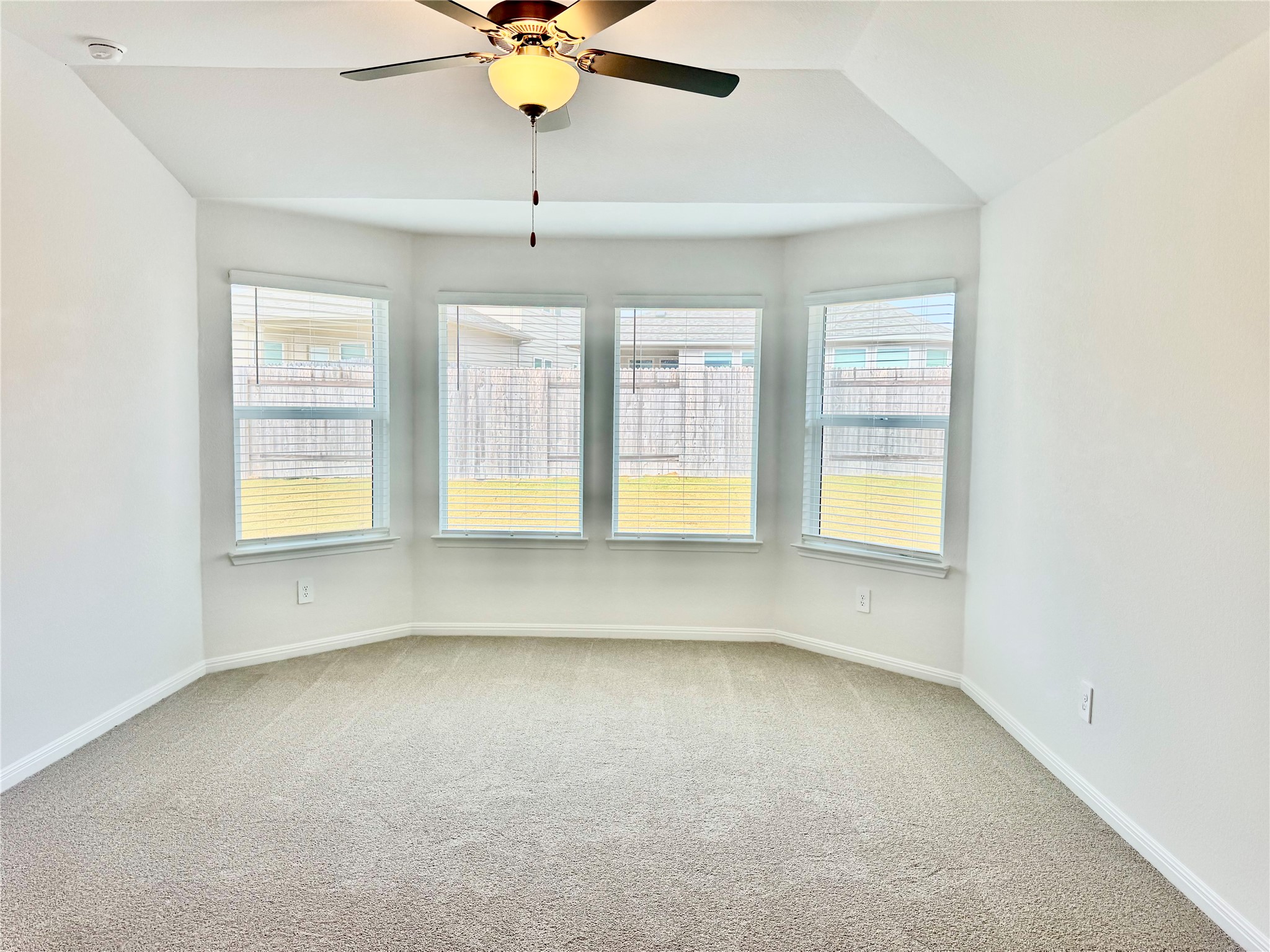 478 El Capitan Loop Dripping Springs, TX 78620 - Photo 3 of 14 an empty room with windows and chandelier fan