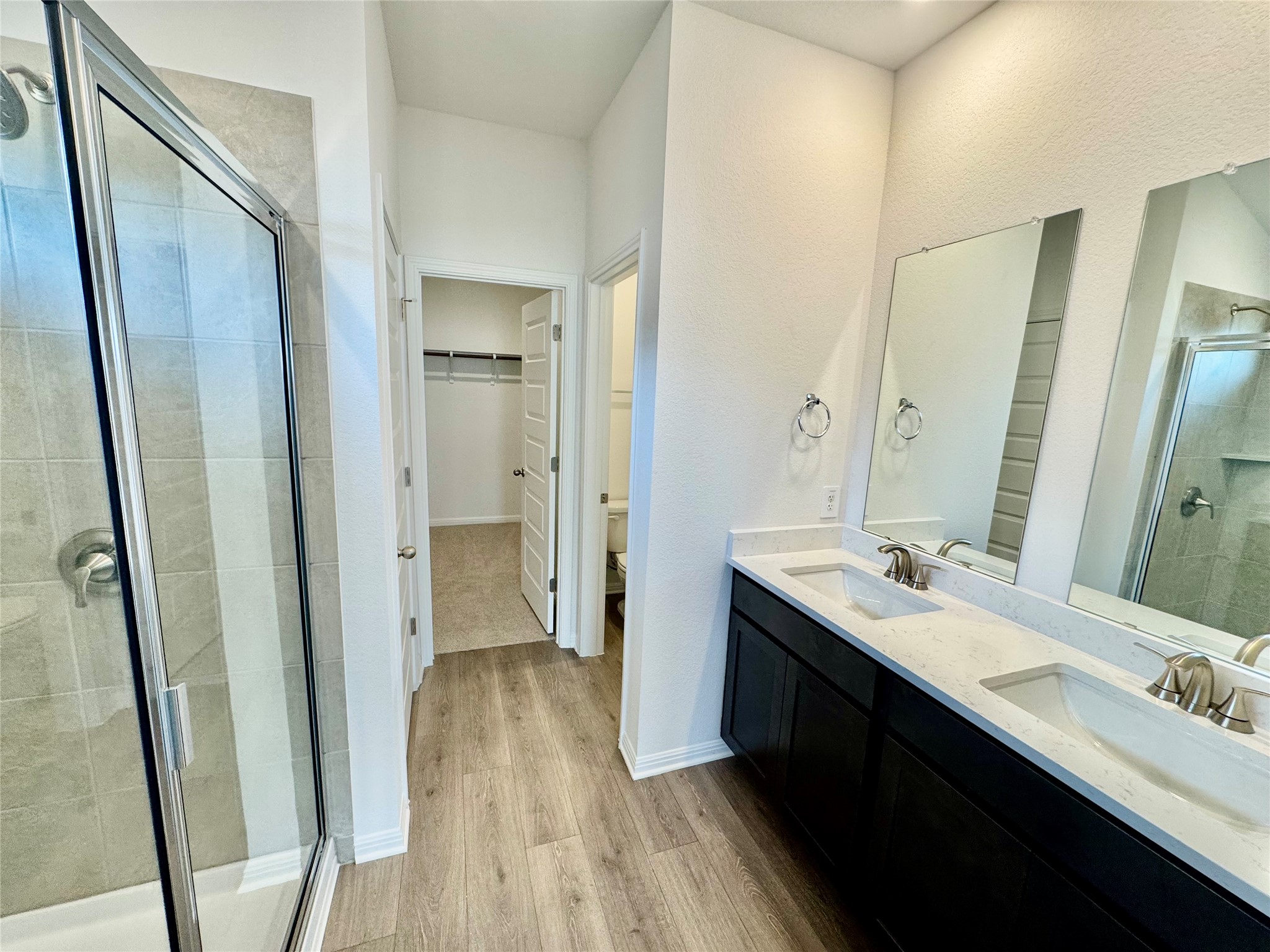 478 El Capitan Loop Dripping Springs, TX 78620 - Photo 4 of 14 a en suite bathroom with a double vanity sink a mirror and a shower