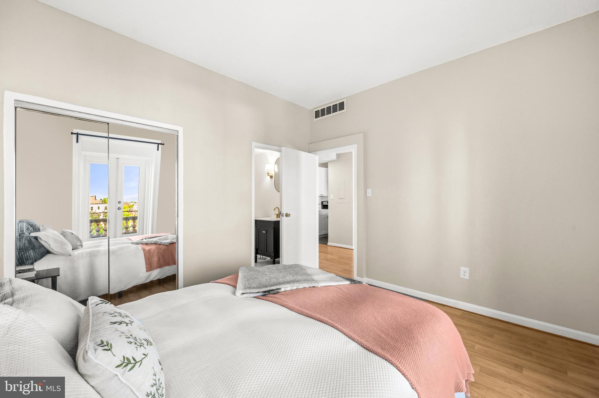 1851 Columbia Road Northwest, Unit 401 Washington, DC 20009 - Photo 18 of 27 a bedroom with a bed and wooden floor