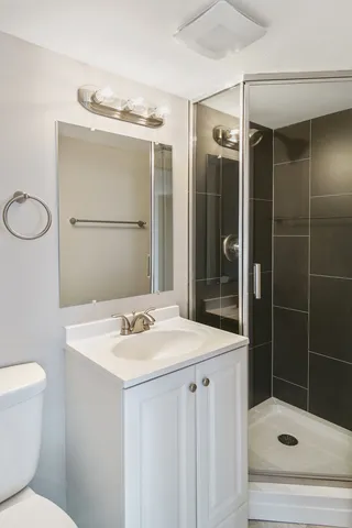 a bathroom with a sink a toilet and shower