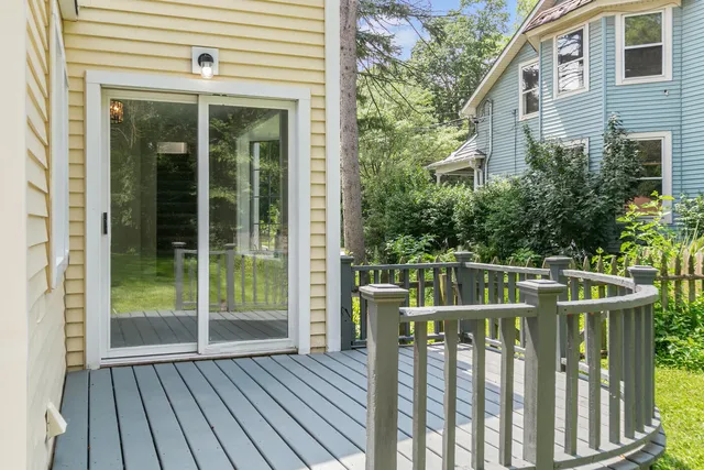 a balcony with wooden floor table and chairs