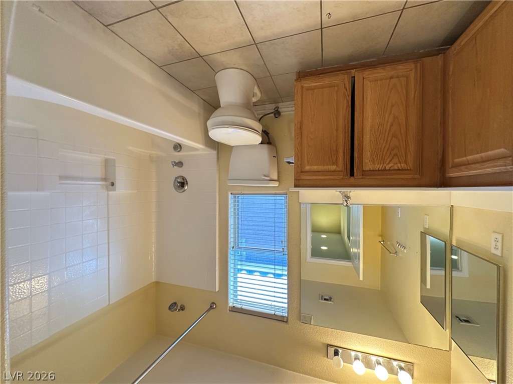 9032 Rutherford Grove Street Las Vegas, NV 89148 - Photo 17 of 24 A well-maintained bathroom with a tiled shower and a window for natural light.