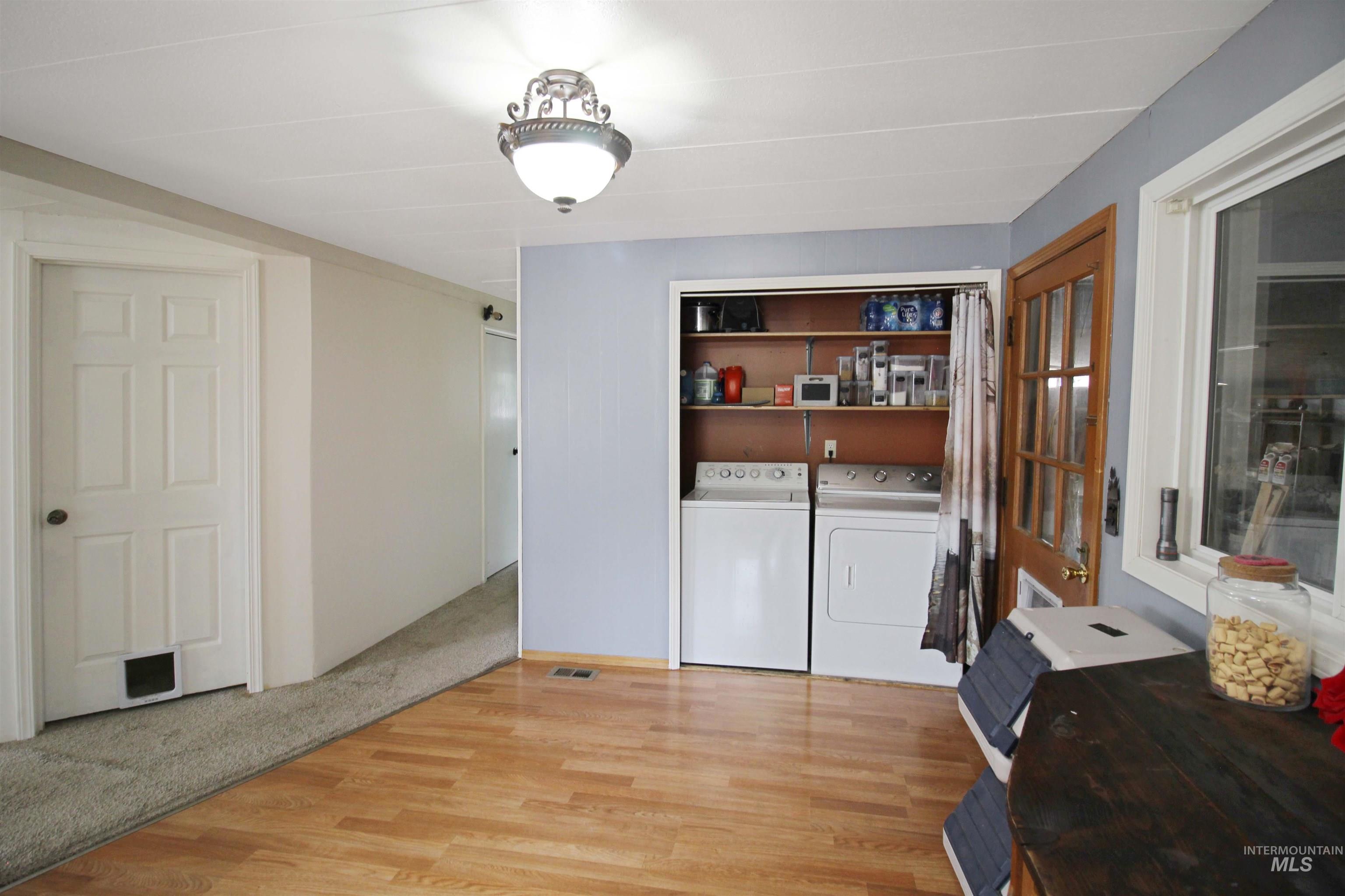 1265 Pioneer Road Weiser, ID 83672 - Photo 13 of 29 Functional laundry area featuring a washer and dryer within a built-in closet with shelving