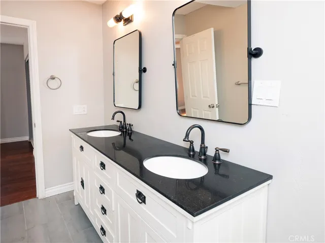 a bathroom with double sink and two mirror