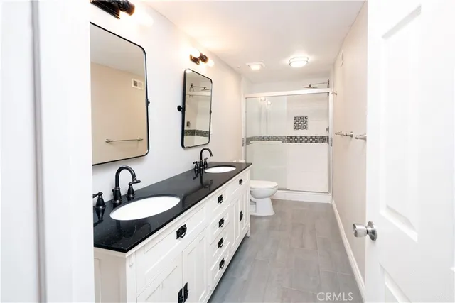 a bathroom with double sink and two mirror