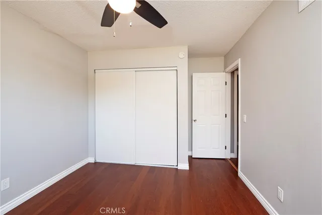 an empty room with a hardwood and ceiling fan