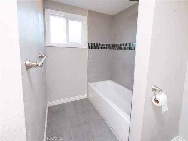 a bathroom with a white bath tub and a shower