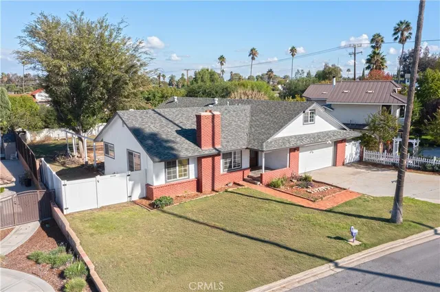 an aerial view of a house with swimming pool and large trees