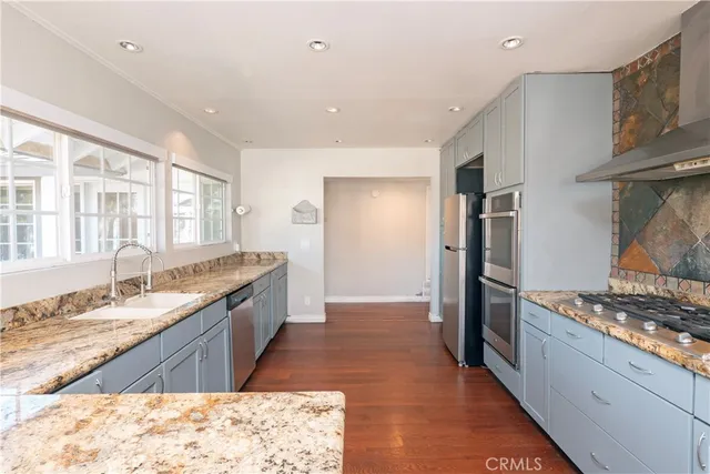 a large kitchen with stainless steel appliances granite countertop a sink stove and refrigerator