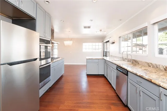 a kitchen with granite countertop a refrigerator a sink dishwasher and a stove