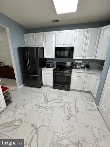 a kitchen with stainless steel appliances a refrigerator a sink a stove a microwave and cabinets