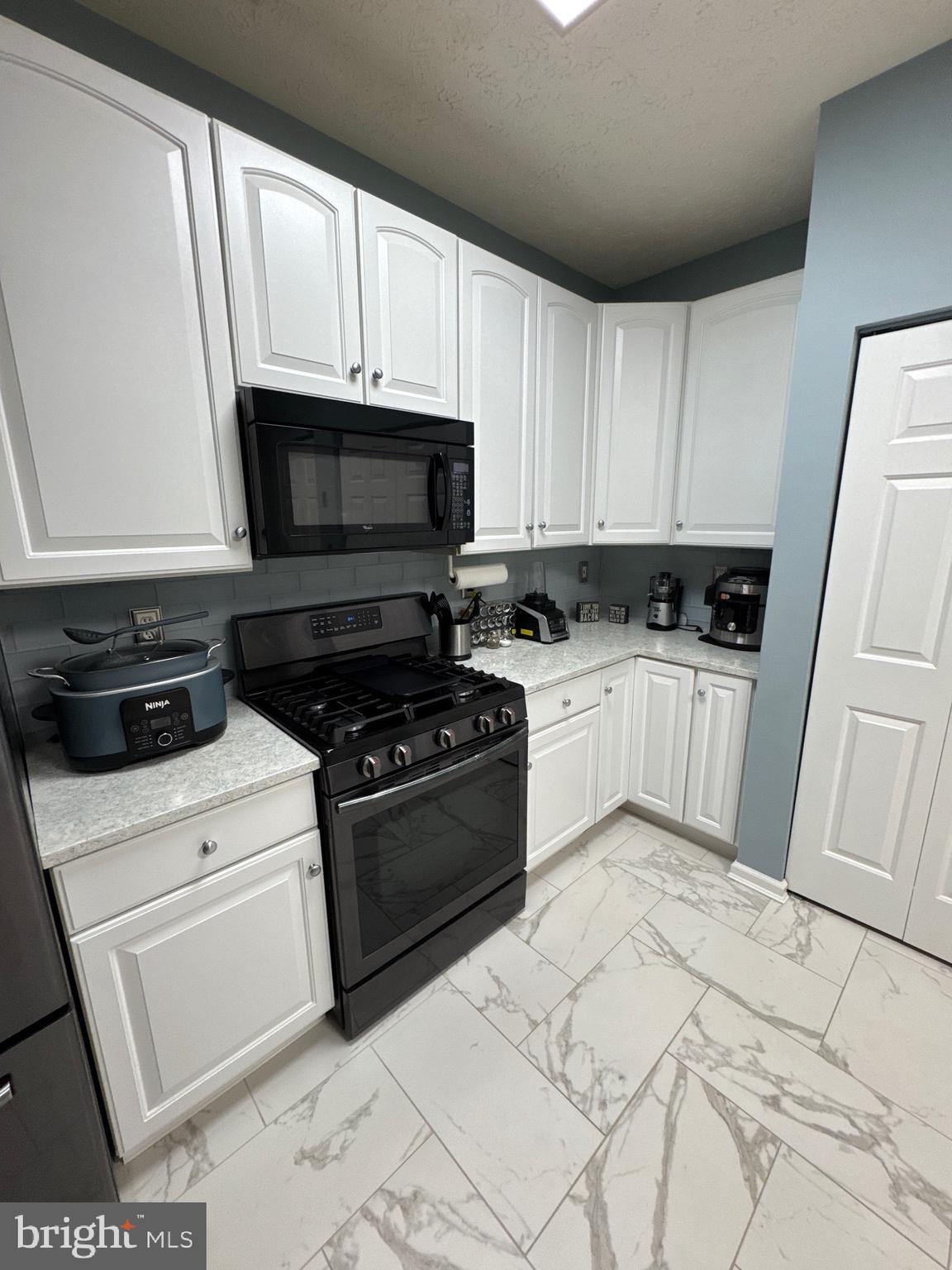 5144 Brightleaf Court, Unit 5144 Rosedale, MD 21237 - Photo 13 of 47 a kitchen with granite countertop white cabinets and white appliances