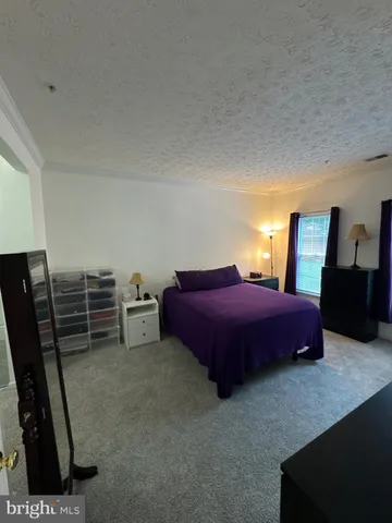 a spacious bedroom with a bed a desk and chair