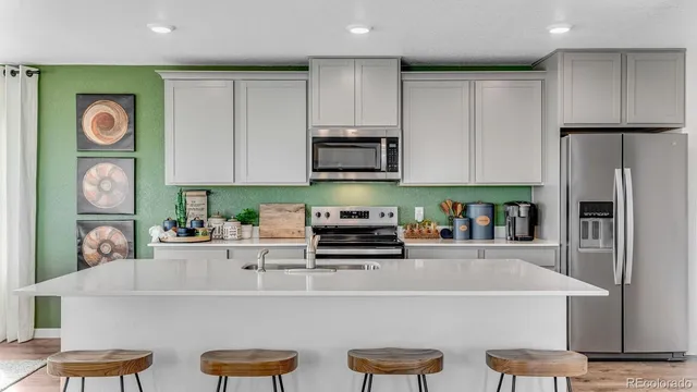 a kitchen with stainless steel appliances granite countertop a refrigerator and a stove top oven