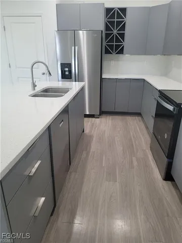 a kitchen with stainless steel appliances a sink cabinets and wooden floor