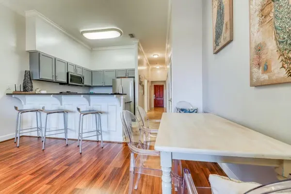 a kitchen with stainless steel appliances a dining table chairs and sink