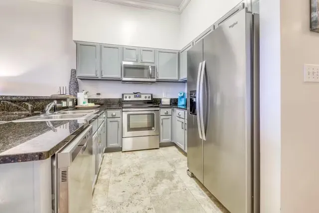 a kitchen with stainless steel appliances granite countertop a stove a sink and a refrigerator