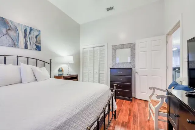 a bedroom with a bed and a flat tv screen on a dresser