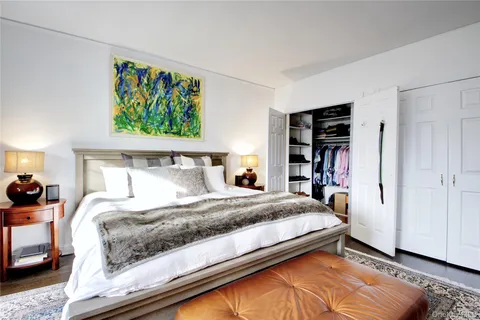 a bedroom with a bed and a painting on the wall
