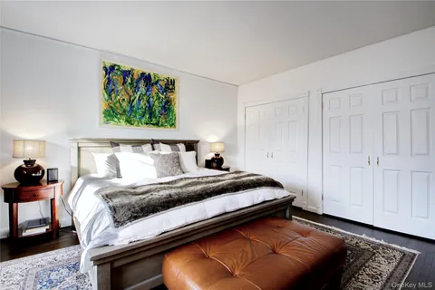 a bedroom with a bed and a painting on the wall