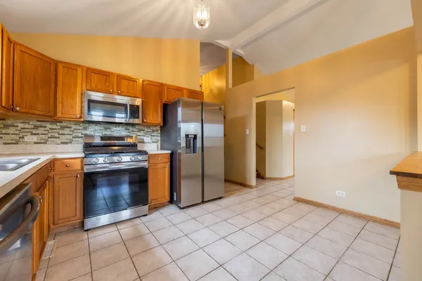 a kitchen with stainless steel appliances granite countertop a refrigerator and a stove top oven