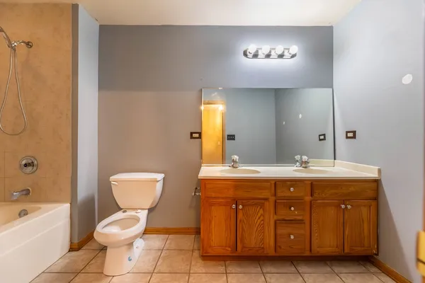 a spacious bathroom with a toilet sink and mirror