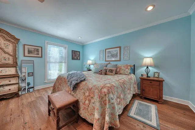 a spacious bedroom with a bed and wooden floor