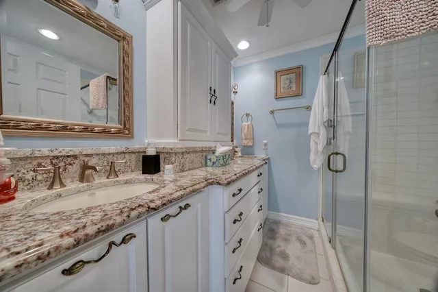 a bathroom with a granite countertop shower sink and mirror