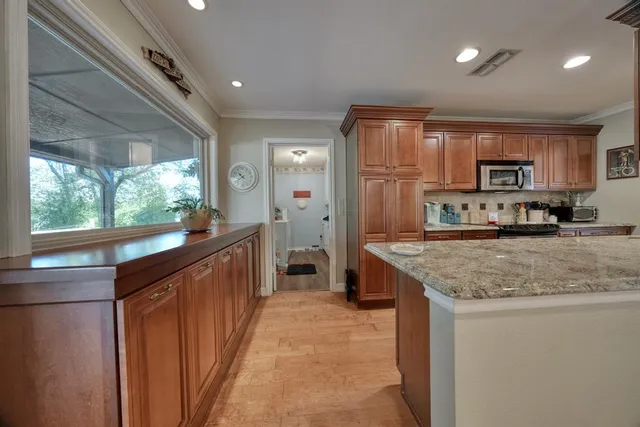 a kitchen with stainless steel appliances granite countertop a stove a sink and a refrigerator