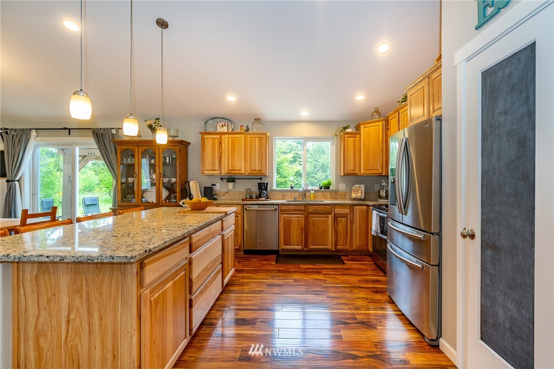 665 Rhoades Road Winlock, WA 98596 - Photo 11 of 39 a kitchen with kitchen island granite countertop a stove a sink and a refrigerator