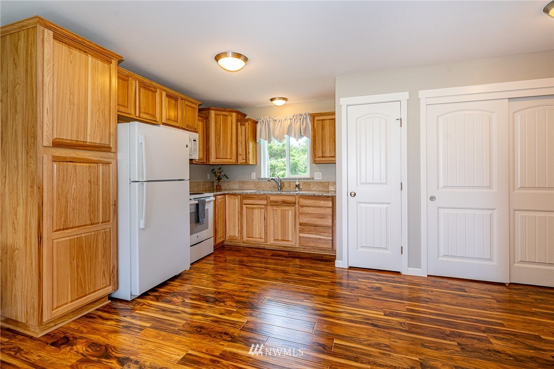 665 Rhoades Road Winlock, WA 98596 - Photo 29 of 39 a kitchen with a refrigerator a sink and cabinets
